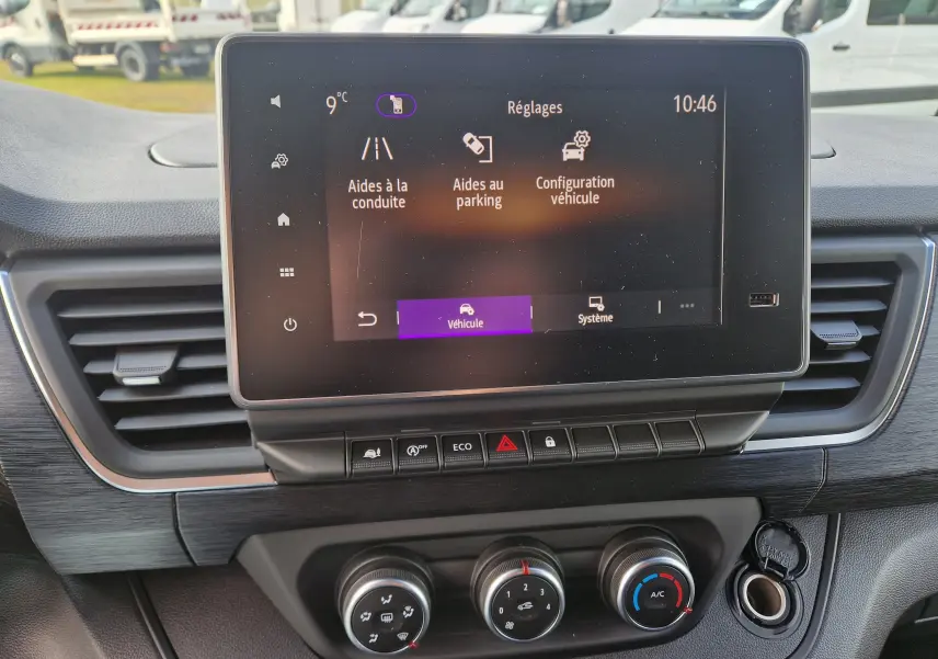 Vue rapprochée de l’écran central tactile et des commandes de climatisation du Nissan Primastar blanc 2025.