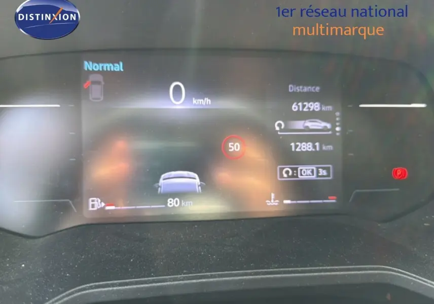 Tableau de bord numérique de Renault Clio V rouge flamme, affichant vitesse, distance et alertes au repos.