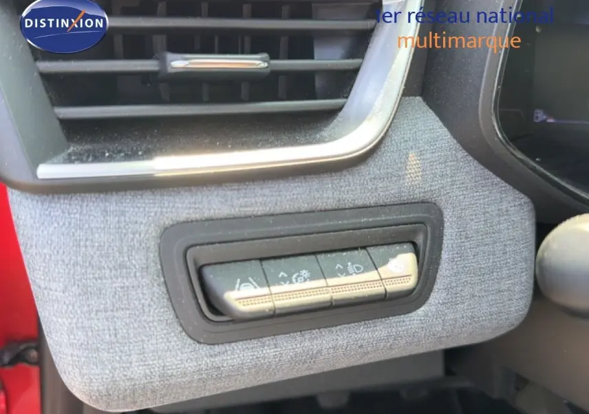 Détail des commandes d'assistance au conducteur sur la partie gauche du tableau de bord de la Renault Clio V rouge flamme.