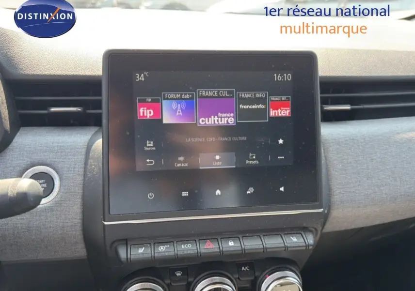 Vue rapprochée de l’écran tactile central et des commandes de la Renault Clio V rouge flamme, intérieur moderne et fonctionnel.