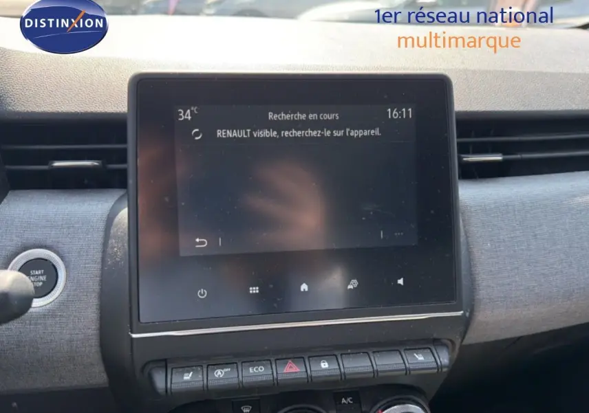 Vue rapprochée de l’écran tactile central et des commandes du tableau de bord de la Renault Clio V rouge flamme 2023.