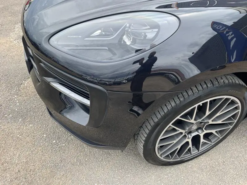 Gros plan sur l'avant droit noir brillant d'une Porsche Macan 2018, mettant en valeur le phare LED et la jante alu sport.