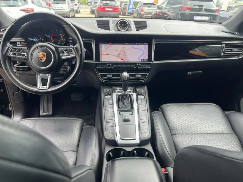 Intérieur noir cuir du Porsche Macan 2.0 2018 vu de face, avec écran tactile central et volant multifonction.