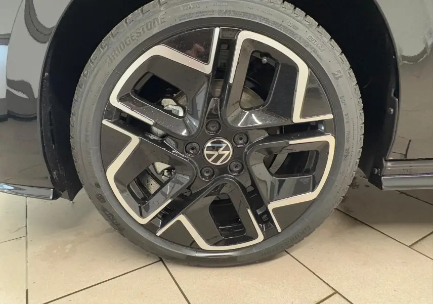 Gros plan sur la roue avant droite noire grenadille de la Volkswagen Golf 2.0 TDI 150 DSG7 R-Line.