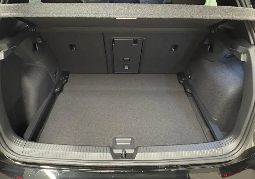 Vue arrière du coffre ouvert de la Volkswagen Golf 2.0 TDI noir grenadille, montrant un espace de chargement propre et spacieux.