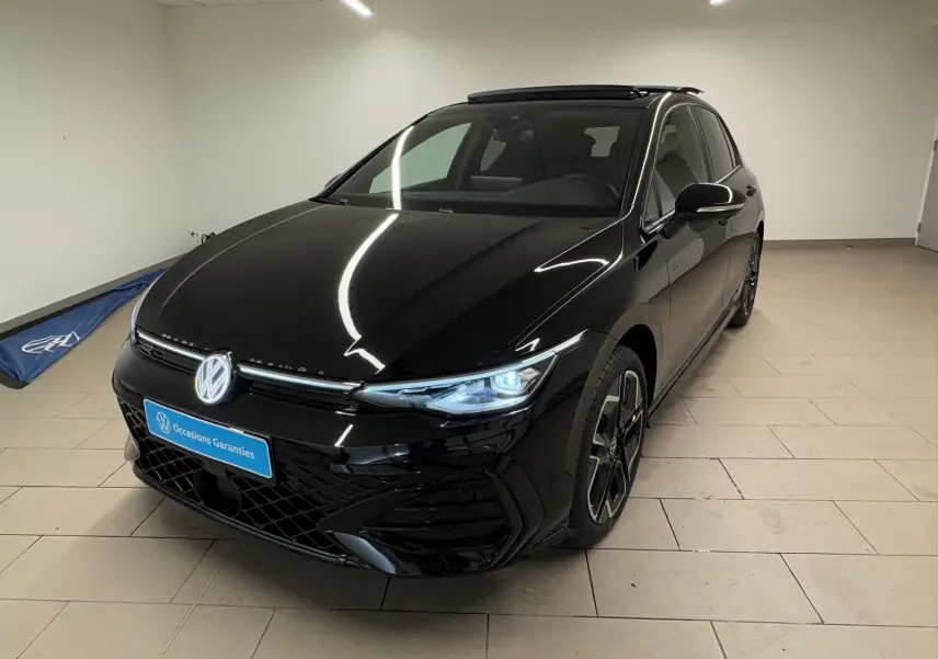 Vue 3/4 avant d'une Volkswagen Golf 2.0 TDI R-Line noire Grenadille avec phares allumés et toit ouvrant panoramique.