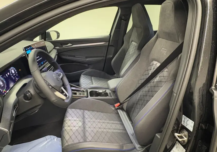 Vue intérieure côté conducteur de la Volkswagen Golf 2.0 TDI R-Line 2026 avec sièges sport gris et volant multifonction.