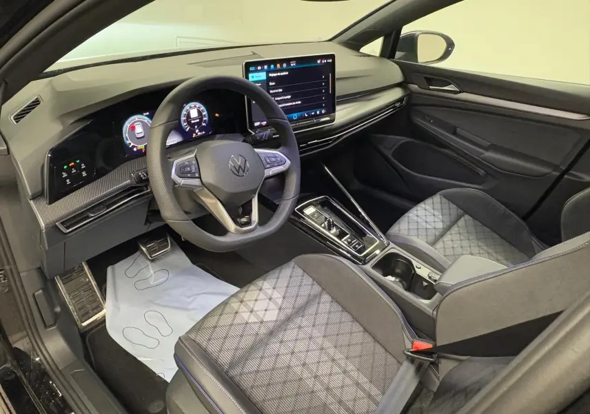 Vue intérieure côté conducteur de la Volkswagen Golf 2.0 TDI R-Line, avec volant cuir multifonction et écran tactile central.