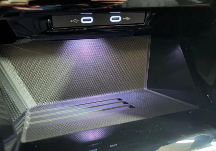 Détail du compartiment de recharge avec ports USB lumineux dans une Volkswagen Golf Noir Grenadille 2026.