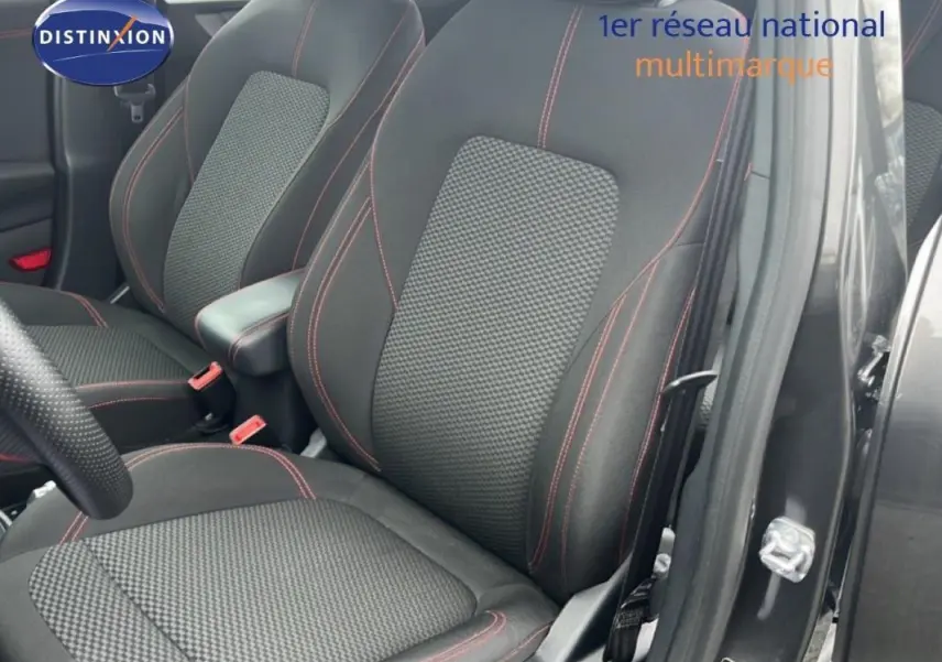 Vue rapprochée des sièges avant noirs avec surpiqûres rouges du Ford Puma gris foncé 2024, porte ouverte côté droit.