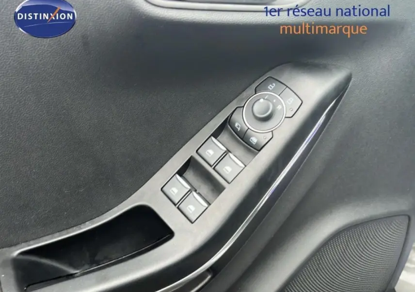Gros plan sur la commande des vitres électriques et rétroviseurs côté conducteur d’un Ford Puma gris foncé 2024.
