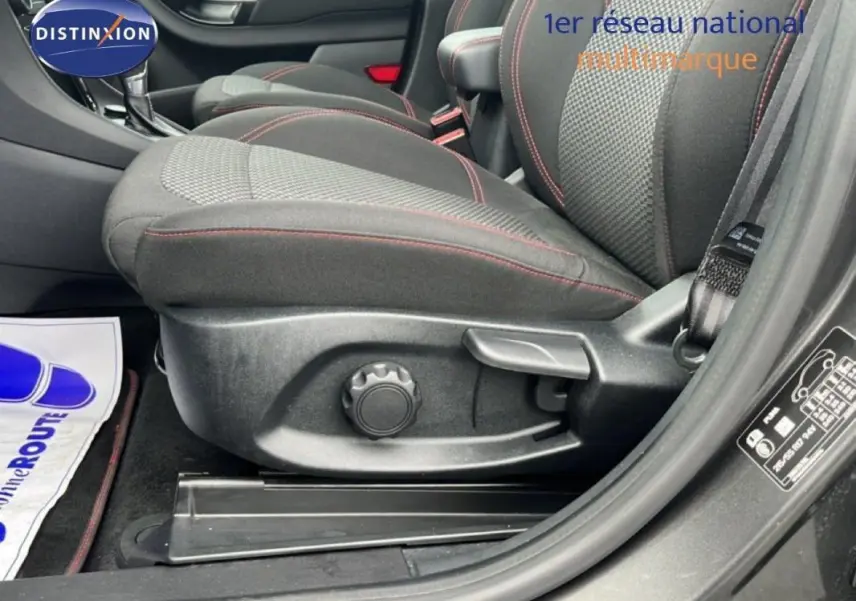 Vue rapprochée du siège avant gauche gris foncé avec surpiqûres rouges du Ford Puma 2024, intérieur tissu.