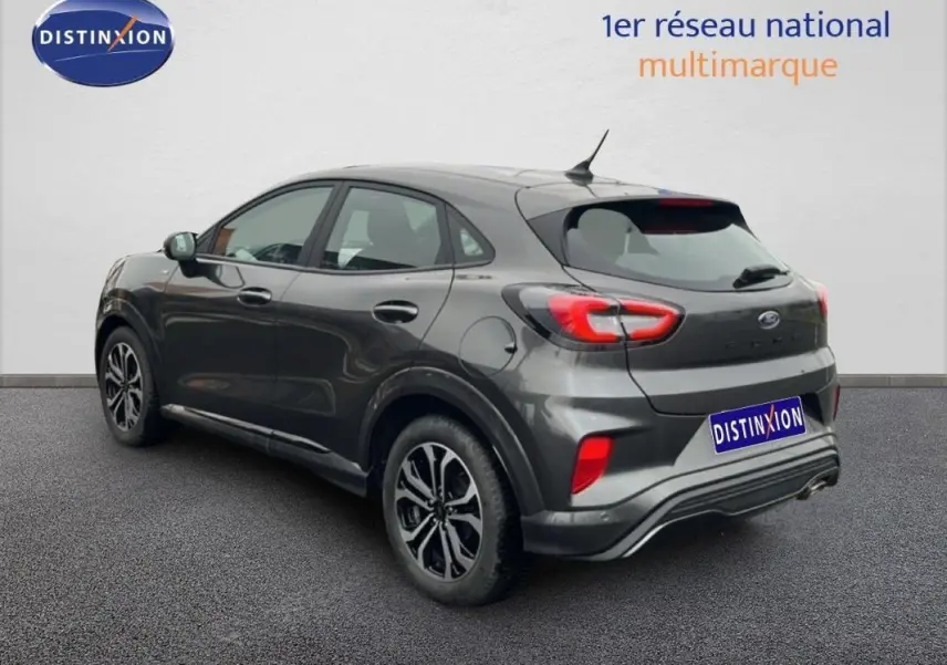 Vue 3/4 arrière droit d'un Ford Puma gris foncé 2024 avec jantes alliage 17 pouces et feux arrière distinctifs.