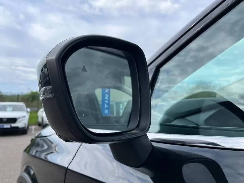 Rétroviseur extérieur côté gauche noir du Nissan Qashqai e-POWER 2024 en noir Kuro métallisé, vue rapprochée sur la portière.