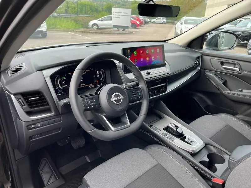 Vue intérieure côté conducteur du Nissan Qashqai e-POWER 2024 avec tableau de bord numérique et écran tactile central.