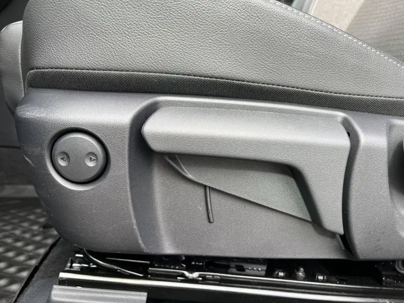 Détail du réglage manuel du siège avant côté conducteur du Nissan Qashqai e-POWER 2024 en sellerie noire.