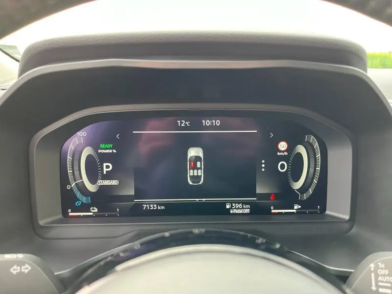 Tableau de bord numérique du Nissan Qashqai e-POWER 2024 affichant la vitesse, la température et l'état des portes ouvertes.