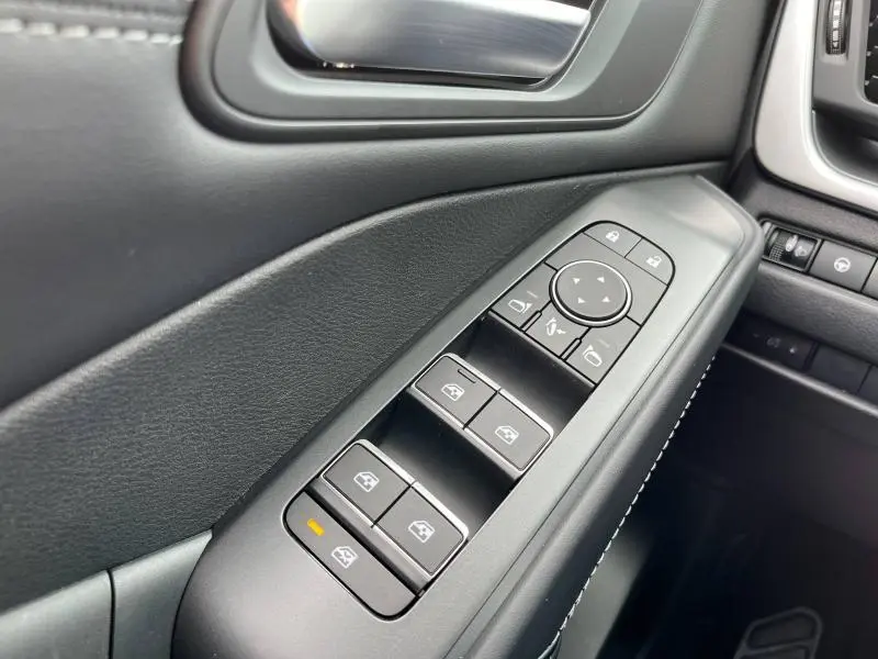 Gros plan sur les commandes de lève-vitres et réglages des rétroviseurs côté conducteur du Nissan Qashqai e-POWER noir 2024.