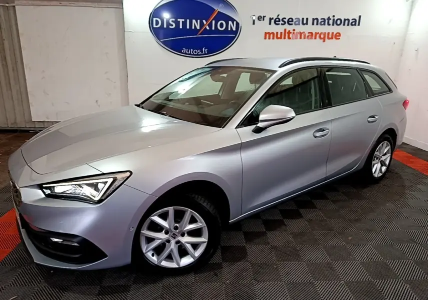 Vue 3/4 avant droit d'une SEAT LEON gris clair 2022 en break, avec feux LED et jantes alliage visibles.