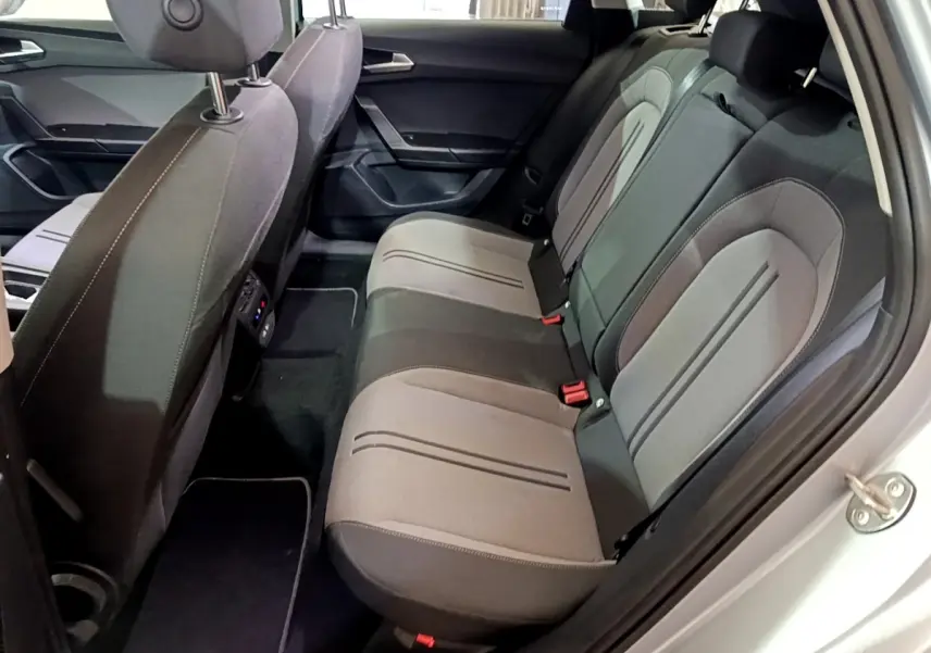 Vue côté droit de l'habitacle arrière gris clair du SEAT LEON 2.0 TDI 150 DSG avec sièges tissu bicolores.