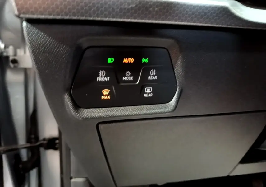 Panneau de commande d’éclairage avec affichage digital dans l’habitacle gris foncé d’une SEAT Leon 2022.