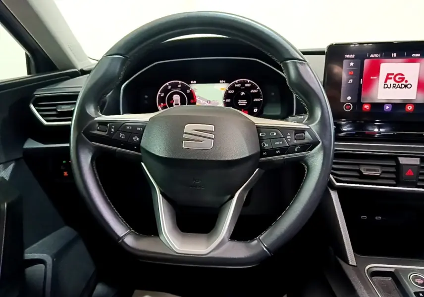 Vue frontale du volant en cuir noir du SEAT LEON 2022 avec tableau de bord numérique et écran tactile multimédia.