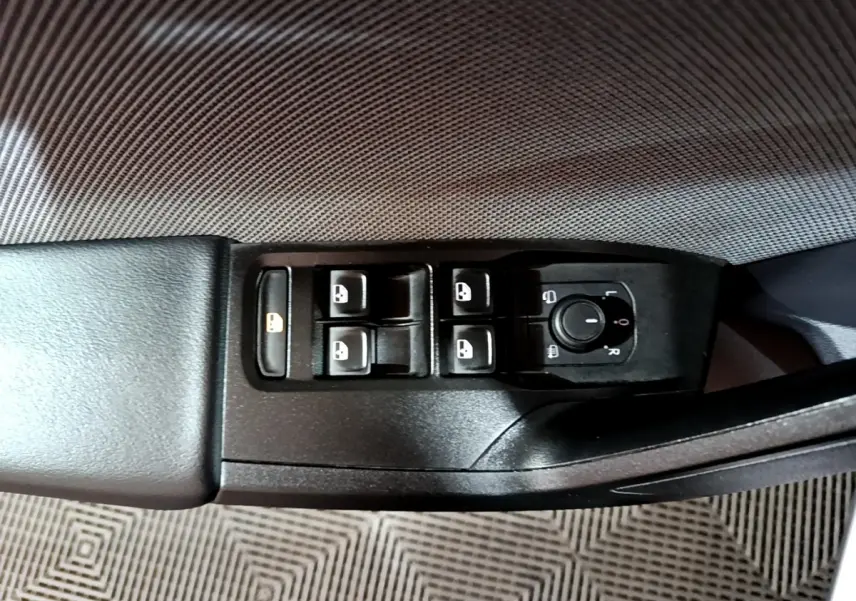 Vue rapprochée du panneau de commandes des vitres et rétroviseurs côté conducteur d'une SEAT Leon gris clair 2022.