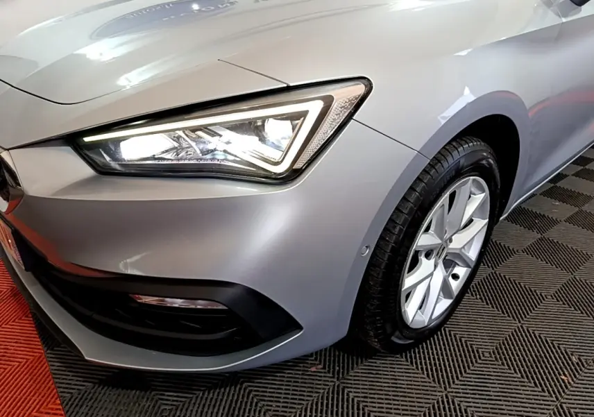 Gros plan sur l'avant droit gris clair d'une SEAT LEON 2022 avec phare LED et jante alliage visible.