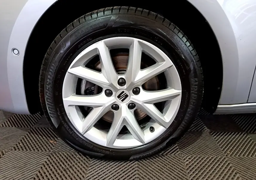 Gros plan sur la roue avant gauche gris clair de la SEAT LEON 2.0 TDI 150 DSG avec jante alliage à 10 branches.