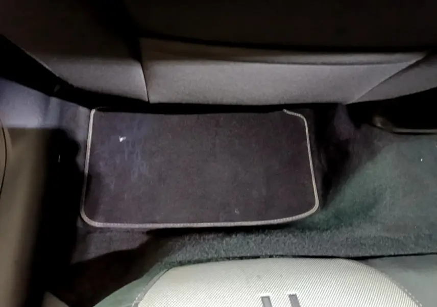 Vue du sol arrière côté conducteur avec tapis noir dans une SEAT LEON gris clair 2022