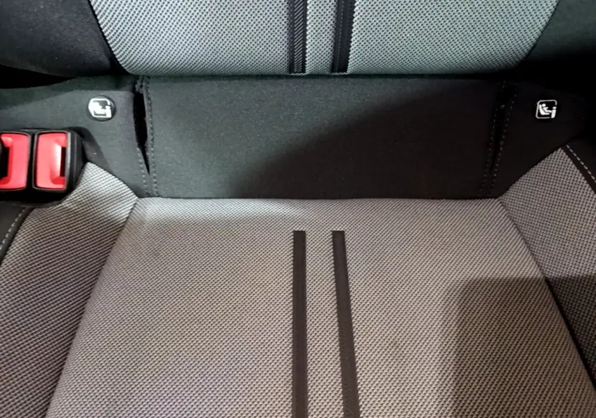 Gros plan sur la banquette arrière grise du SEAT LEON 2022 avec logos Isofix et boucles de ceinture rouges visibles.