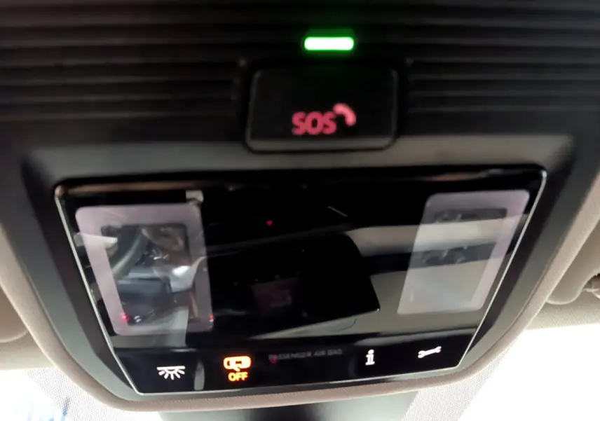Panneau de commande intérieur avec bouton SOS illuminé en rouge sur SEAT Leon gris clair, vue du plafond cabine.