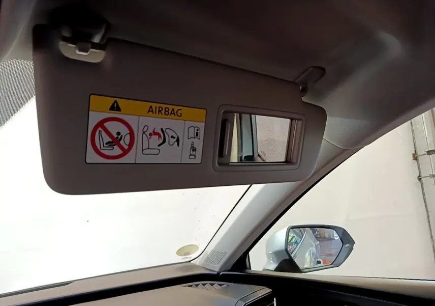 Vue intérieure côté conducteur du SEAT Leon gris clair 2022, avec pare-soleil et miroir intégré visible.