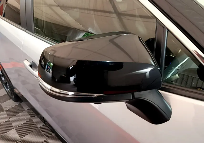 Rétroviseur noir brillant côté gauche du Toyota RAV4 gris clair 2WD 218ch Collection, vue rapprochée sur porte et vitre.