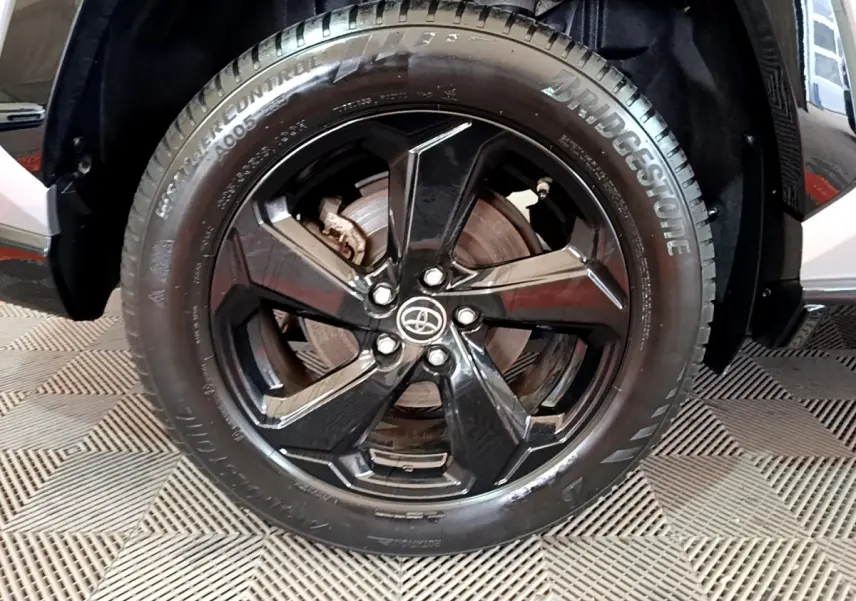 Gros plan sur la roue avant droite noire brillante du Toyota RAV4 gris clair 2WD 218ch Collection 2019.