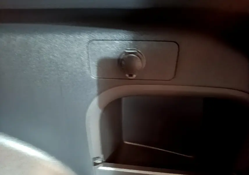 Prise 12V dans le coffre du Toyota RAV4 2WD gris clair, détail intérieur du rangement arrière.