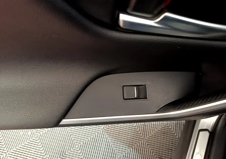 Gros plan sur la commande de verrouillage de porte côté conducteur dans l'habitacle noir du Toyota RAV4 gris clair 2019.