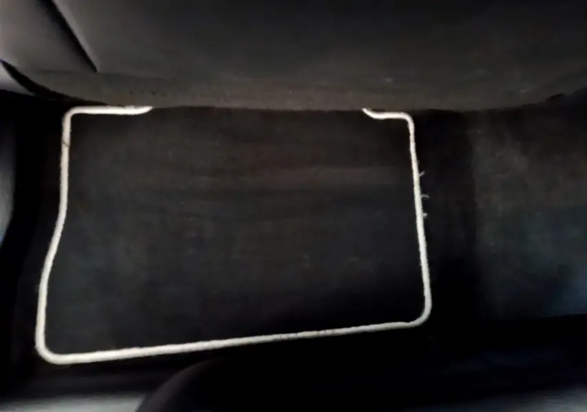 Tapis de sol noir avec bordure claire au sol côté passager arrière du Toyota RAV4 gris clair 2019.
