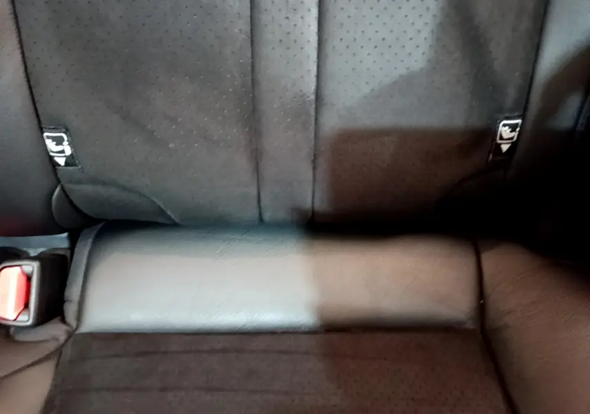 Gros plan sur la banquette arrière noire perforée du Toyota RAV4 2WD 218ch Collection avec ceintures visibles.