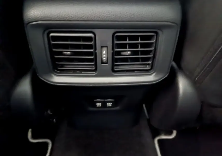 Gros plan sur les aérateurs arrière noirs et prises USB du Toyota RAV4 gris clair, intérieur arrière passager.