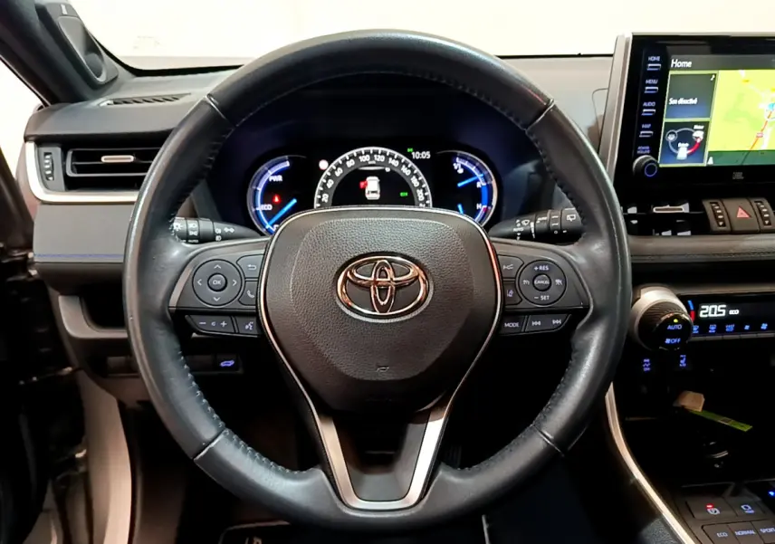 Vue rapprochée du volant cuir noir Toyota RAV4 2WD 218ch Collection 2019 avec tableau de bord et écran tactile visible.