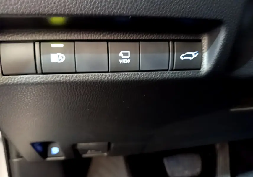 Boutons de commande du tableau de bord noir du Toyota RAV4 gris clair, avec fonction ouverture coffre et affichage caméra.
