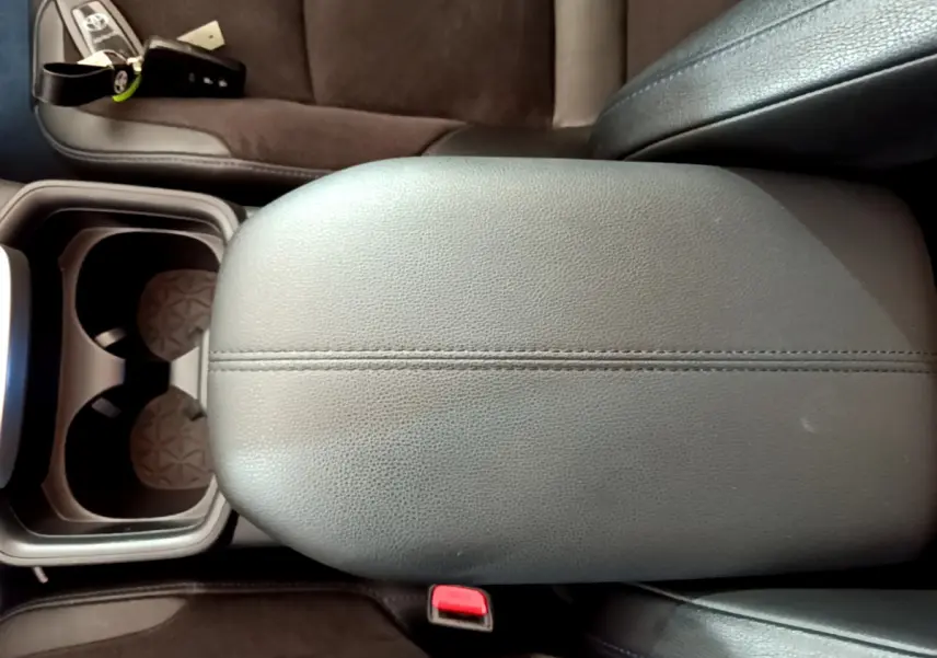 Vue rapprochée de l'accoudoir central en cuir noir et porte-gobelets du Toyota RAV4 gris clair 2WD 2019.