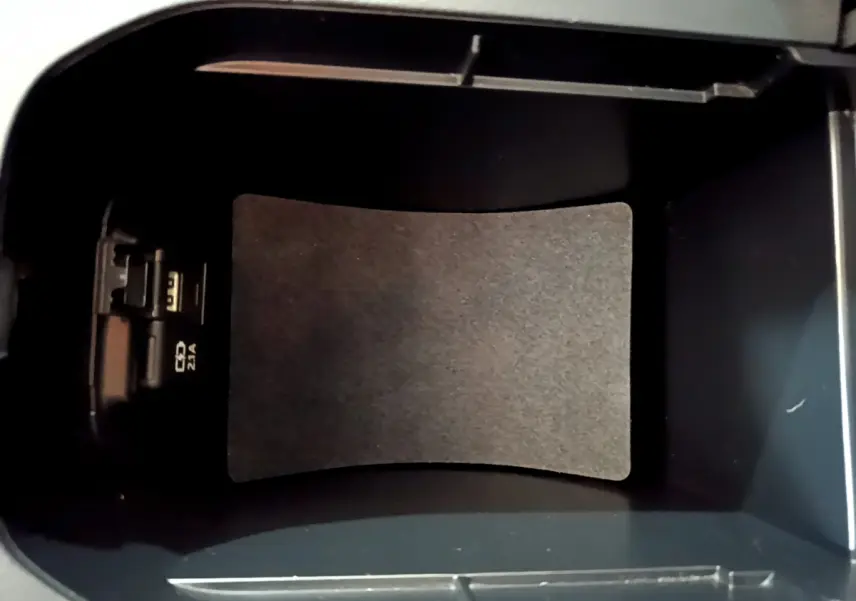 Vue intérieure du compartiment de rangement central noir du Toyota RAV4 gris clair 2019, avec prise USB visible à gauche