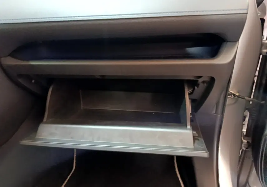 Gros plan sur la boîte à gants ouverte côté passager du Toyota RAV4 gris clair 2WD 2019.