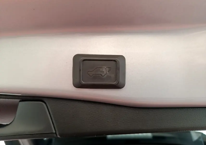 Bouton d'ouverture électrique du coffre sur la partie intérieure du hayon du Toyota RAV4 gris clair 2019.