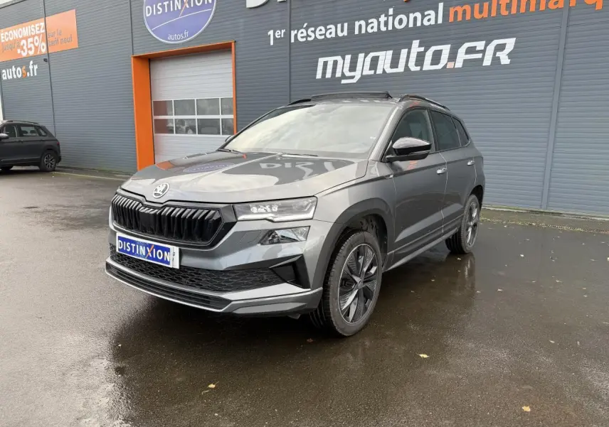 SKODA KAROQ 1.5 TSI Sportline gris graphite métallisé en 3/4 avant avec jantes alliage et toit panoramique.