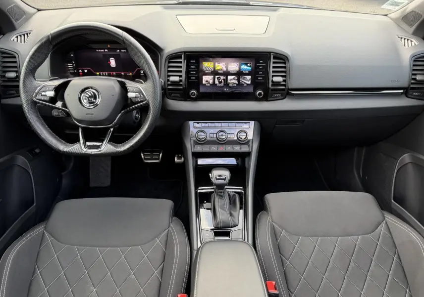Intérieur noir du Skoda Karoq 2023 vu de face, avec tableau de bord digital et console centrale moderne.