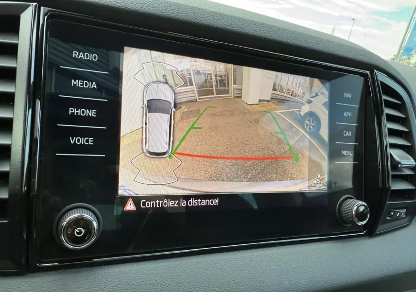 Écran tactile intérieur du Skoda Karoq 2023 montrant la caméra de recul avec guidage de stationnement actif.