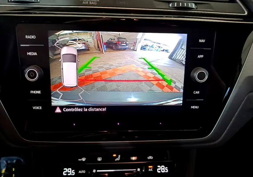 Écran tactile central du Volkswagen Touran 2023 montrant l’aide au stationnement arrière avec guidage couleur.